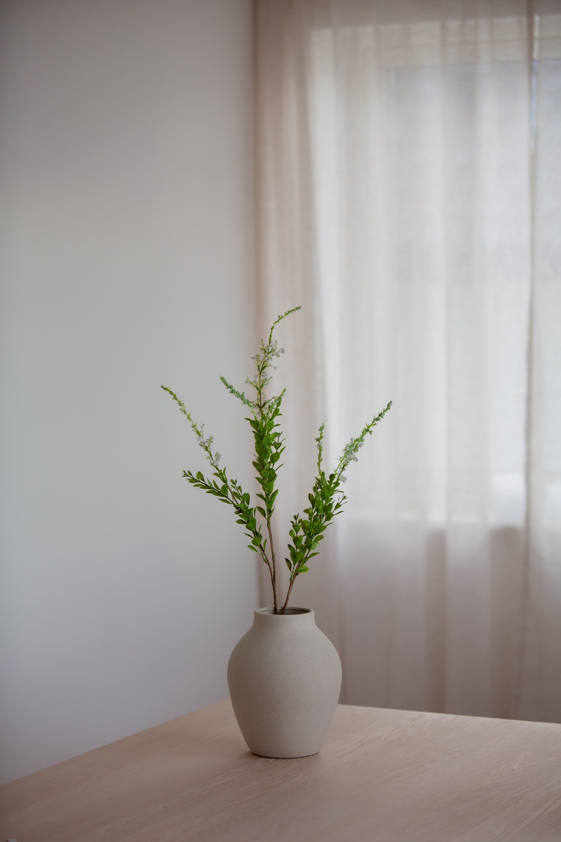 Kunstig villblomst i hvit med grønt i vase