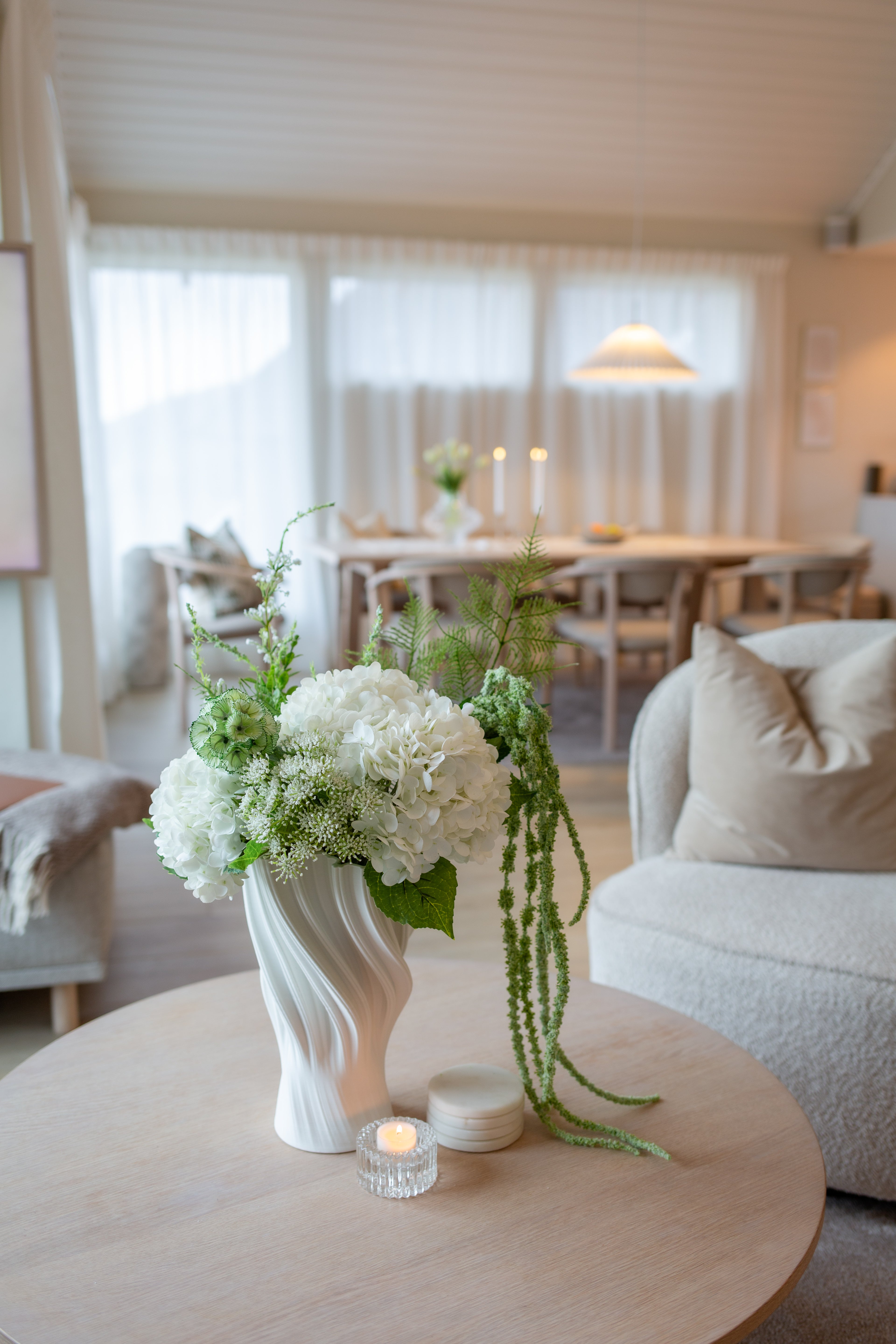 Kunstige blomster i hvit og grønn bukett i vase