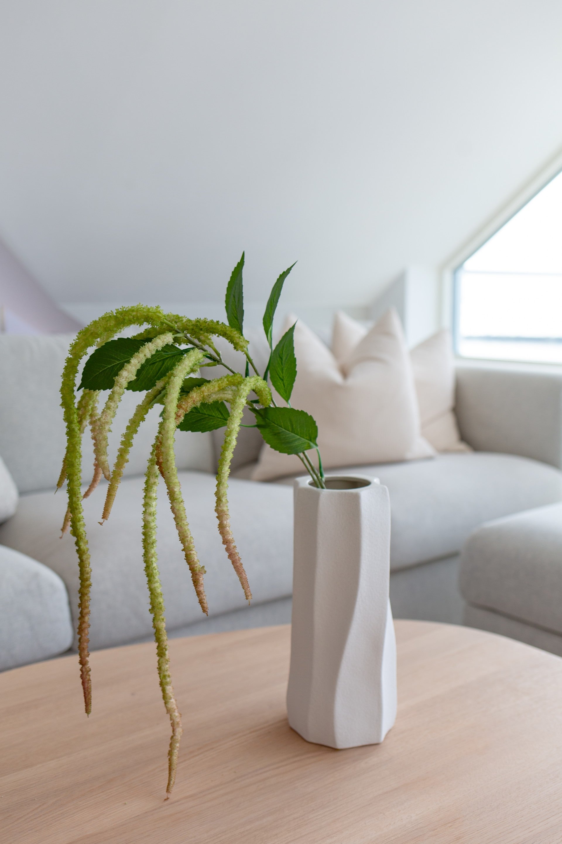 Kunstig amaranthus i rødgrønne toner som del av en dekorasjon med kunstige blomster