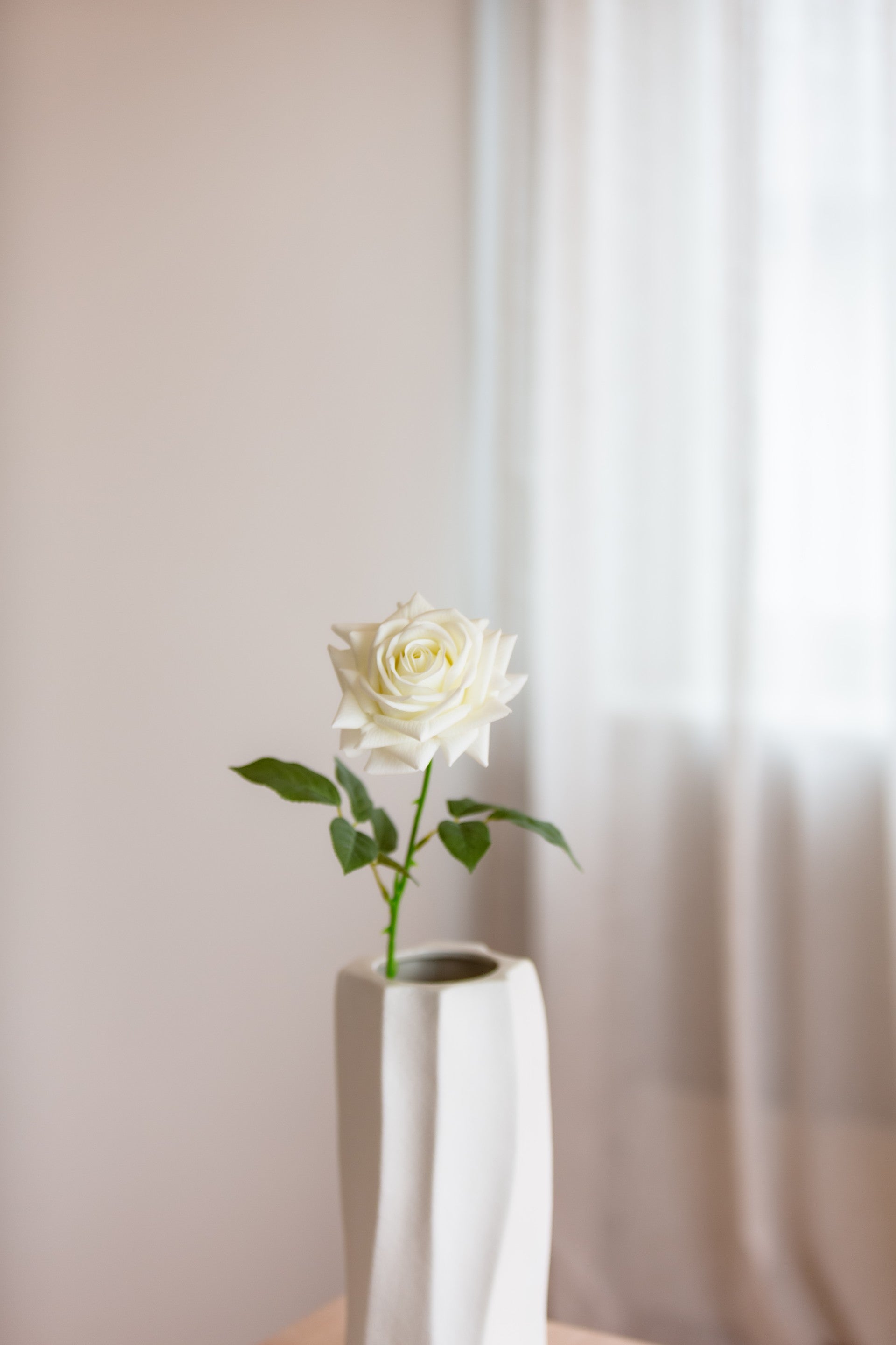 Kunstig hvit rose i vase med et elegant og tidløst uttrykk