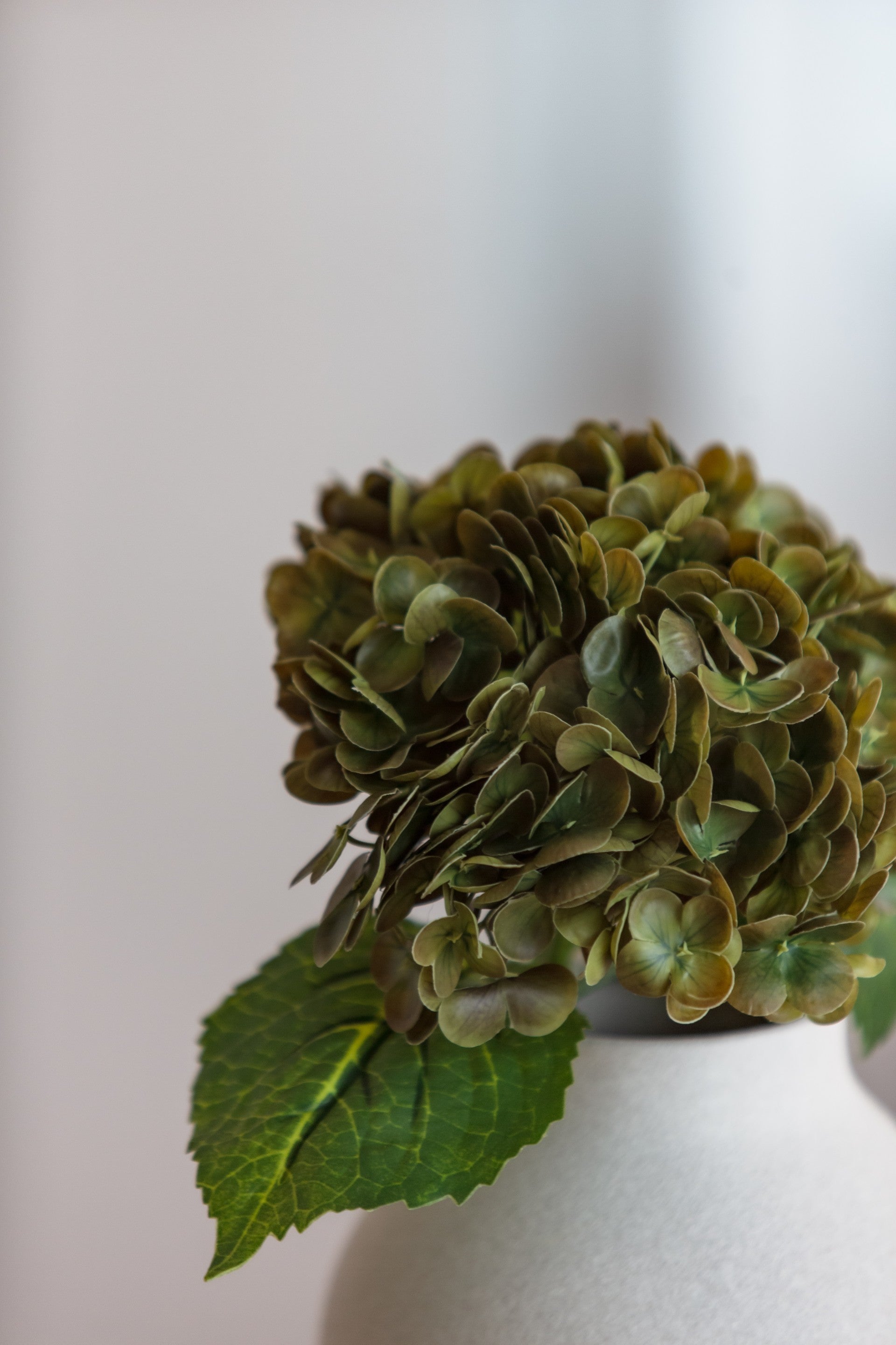 Kunstig hydrangea blomst med fyldige kronblader i olivengrønn farge
