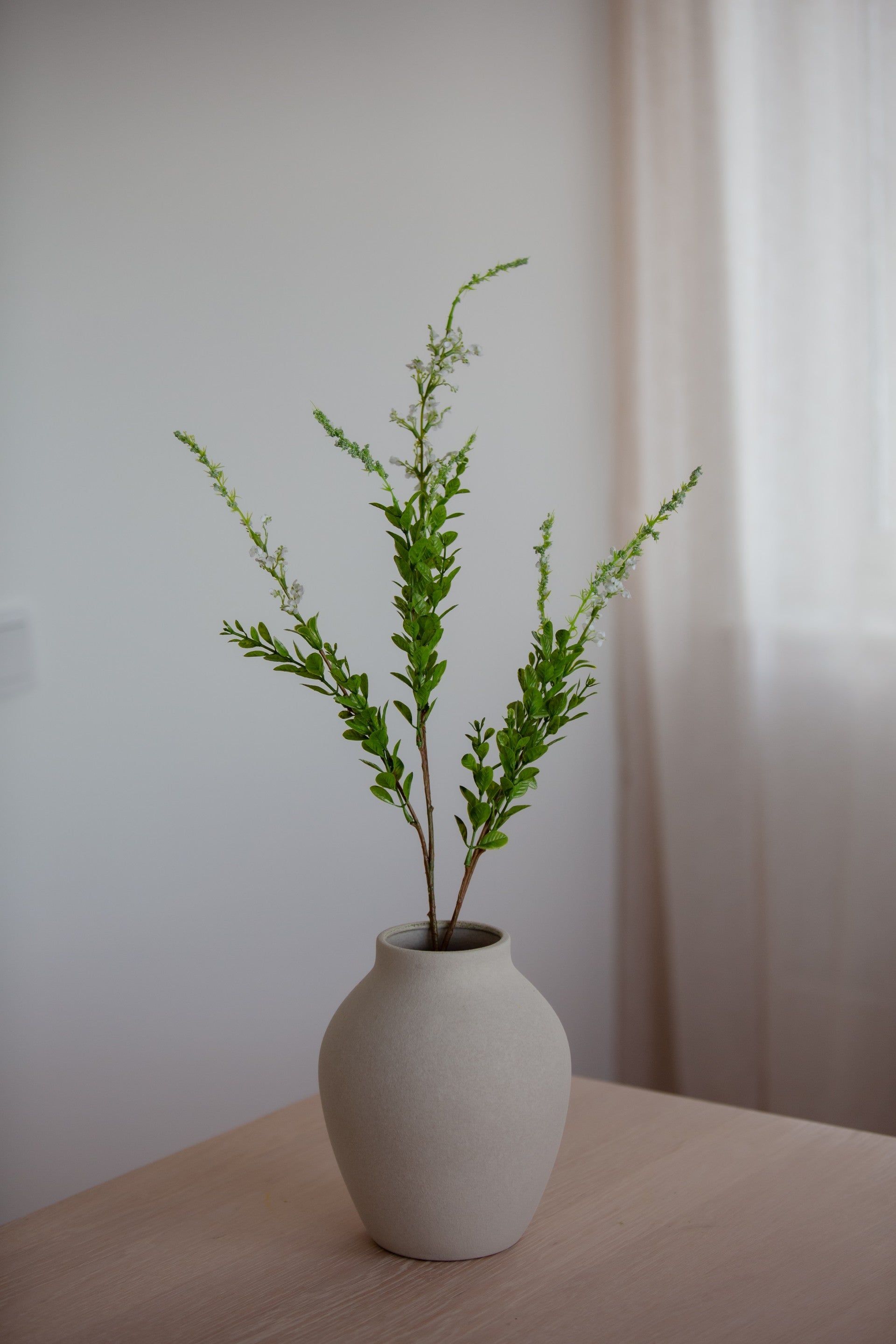 Kunstig villblomst i hvit med grønt i vase